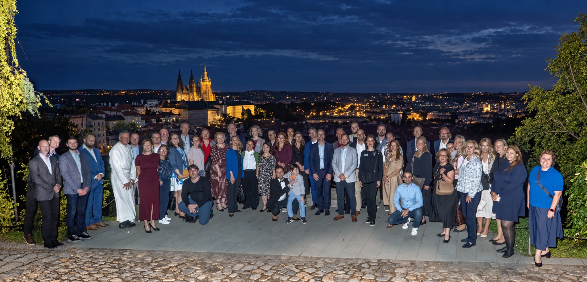 Group photograph of the event guests overlooking Prague at night